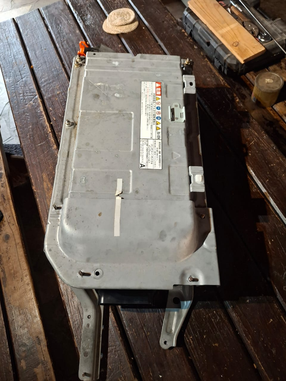 Complete EV battery pack case on a wooden workbench before inspection. Client-supplied Dieselman Nam service image.