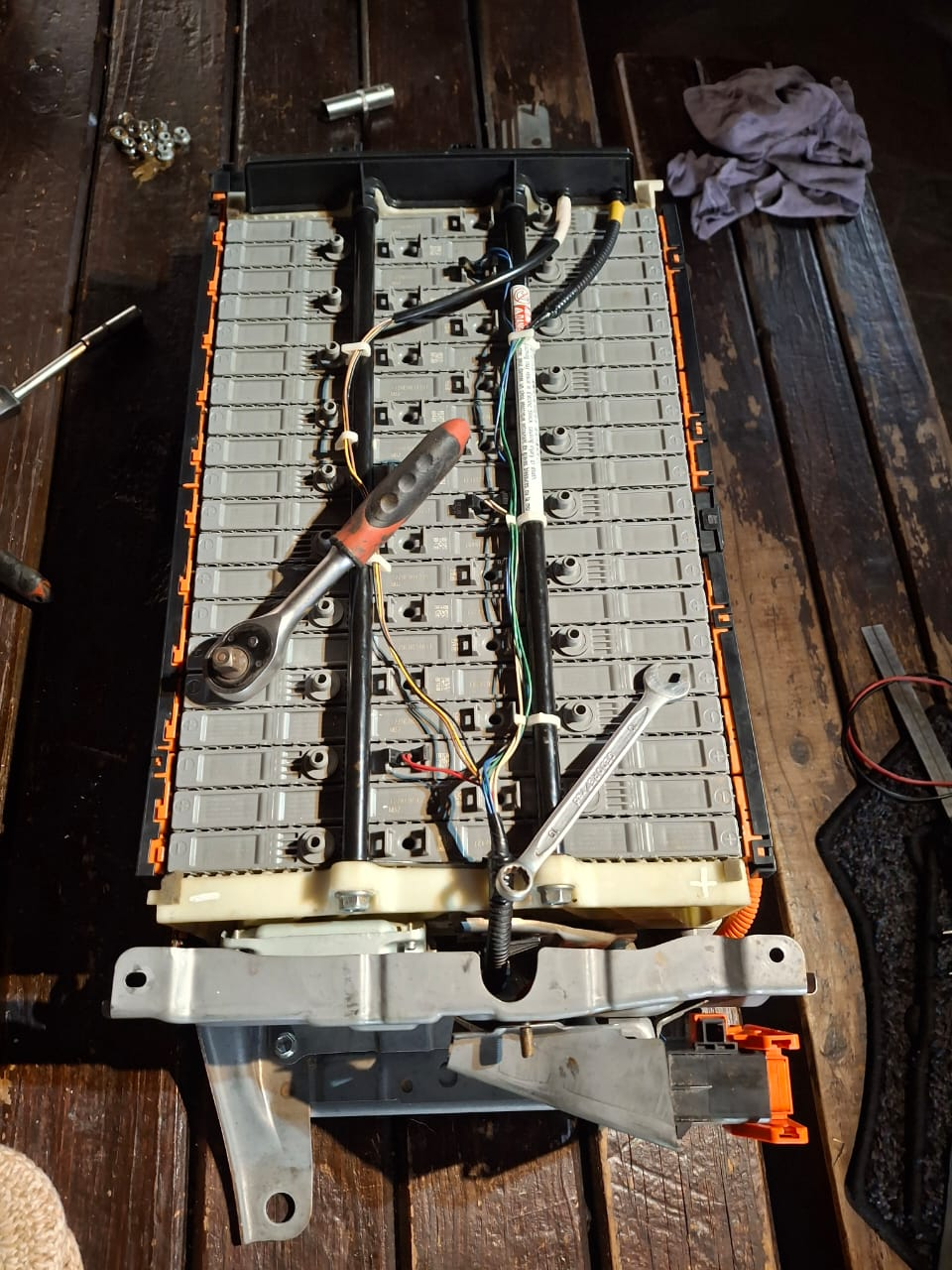 Open EV battery pack with modules, wiring, ratchet and spanner during service work. Client-supplied Dieselman Nam image.