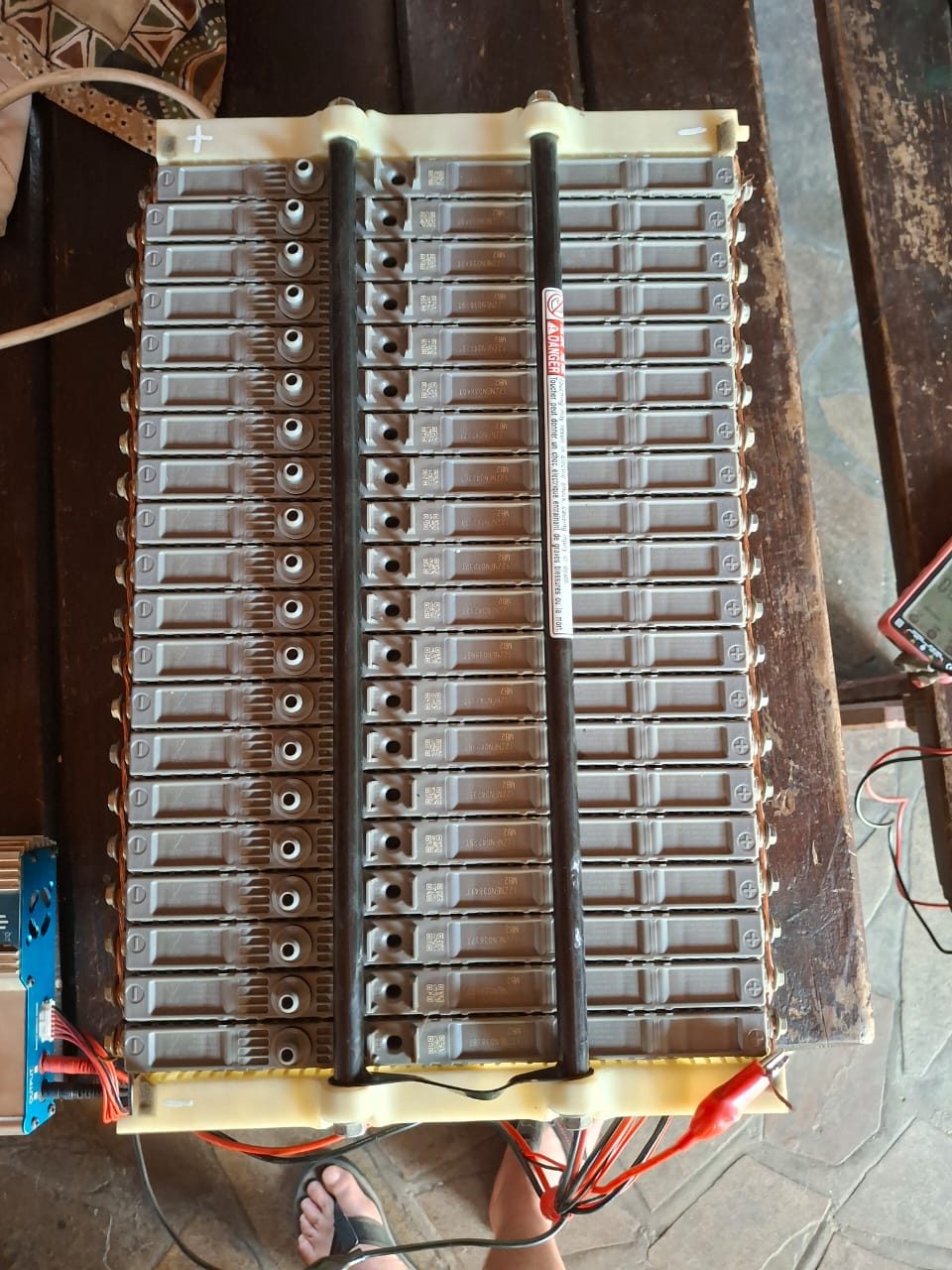 Electric vehicle battery pack being checked on a workbench with test leads attached. Client-supplied Dieselman Nam service image.