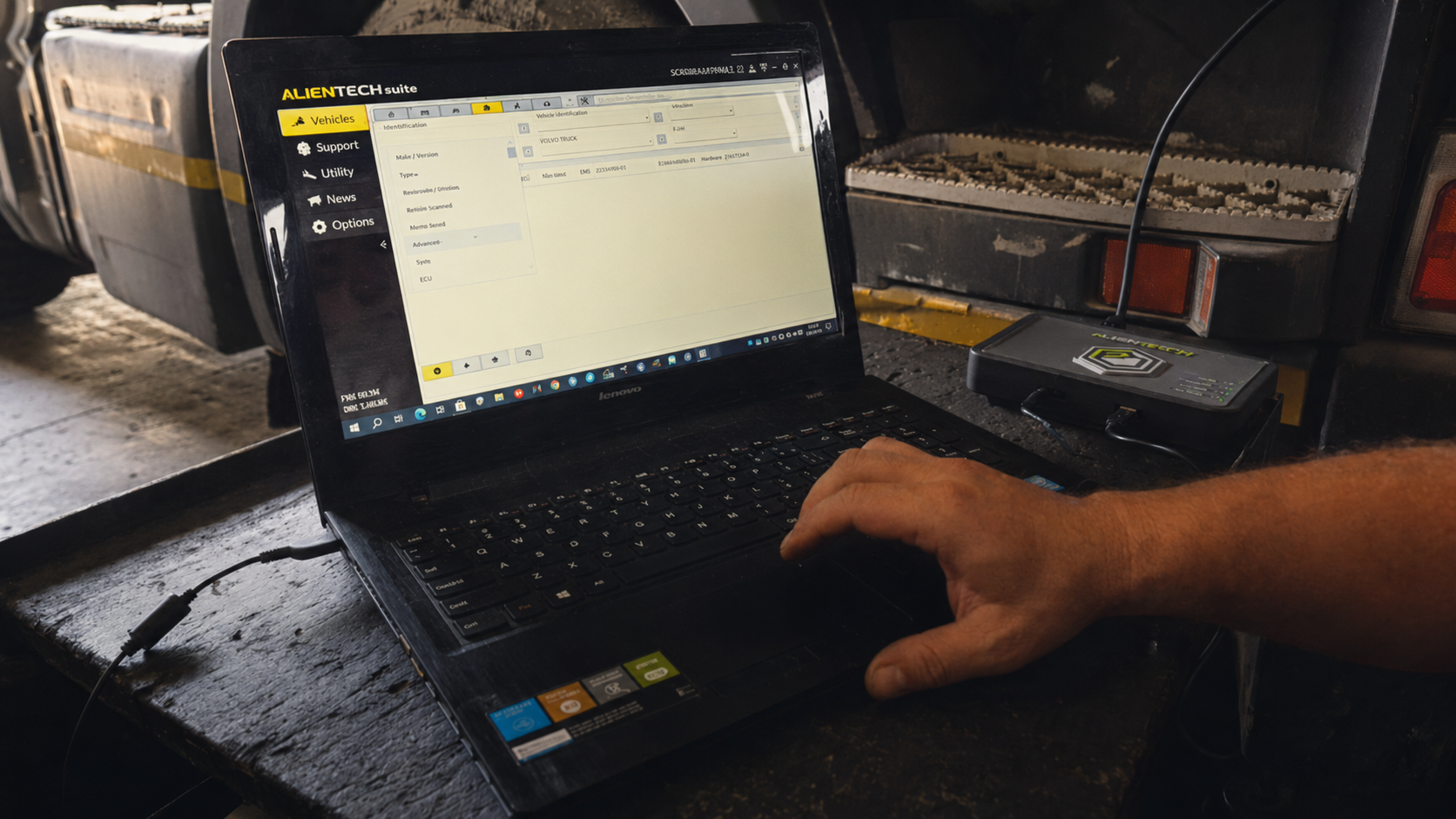 Diagnostic laptop and mechanic's hand on a heavy-duty vehicle, restored from real client workshop footage.
